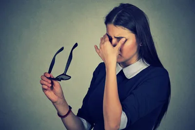 Woman rubbing her eyes with a headache