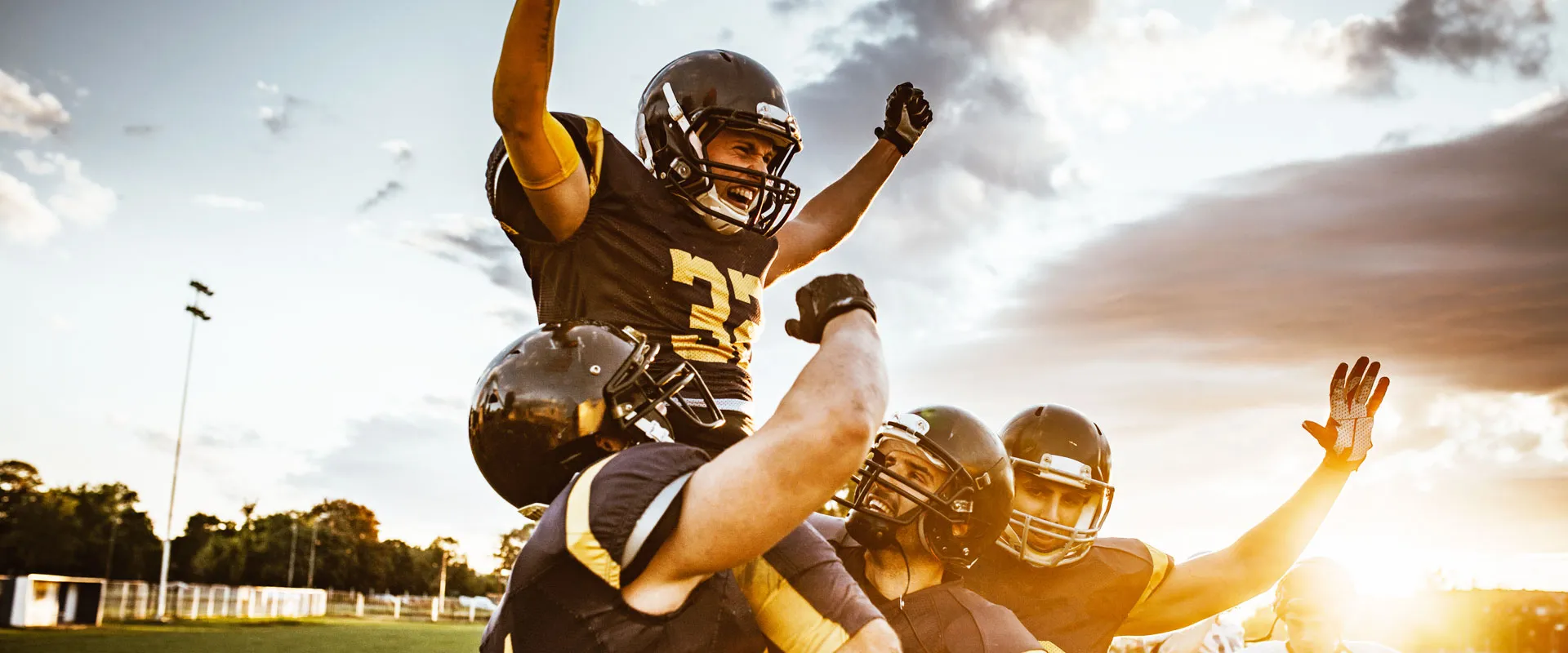 Football players celebrating at sunset